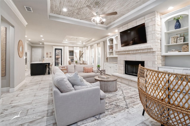 living room featuring a fireplace, ceiling fan, wooden ceiling, a tray ceiling, and crown molding