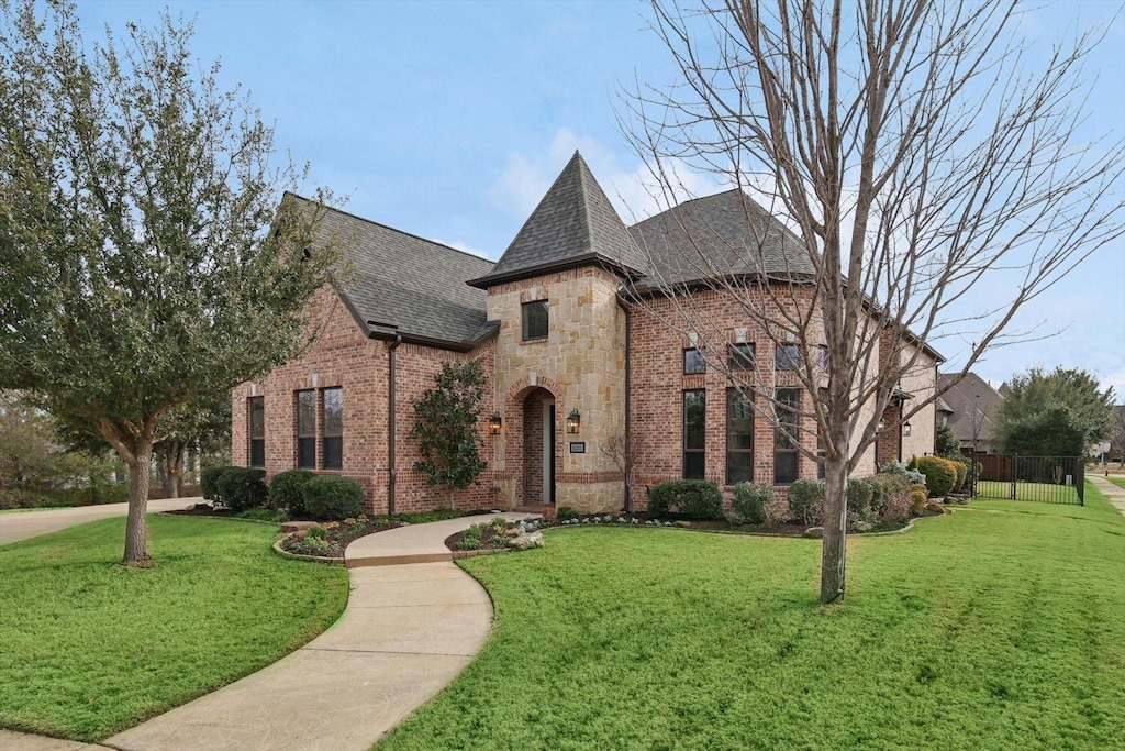 french country inspired facade featuring a front yard