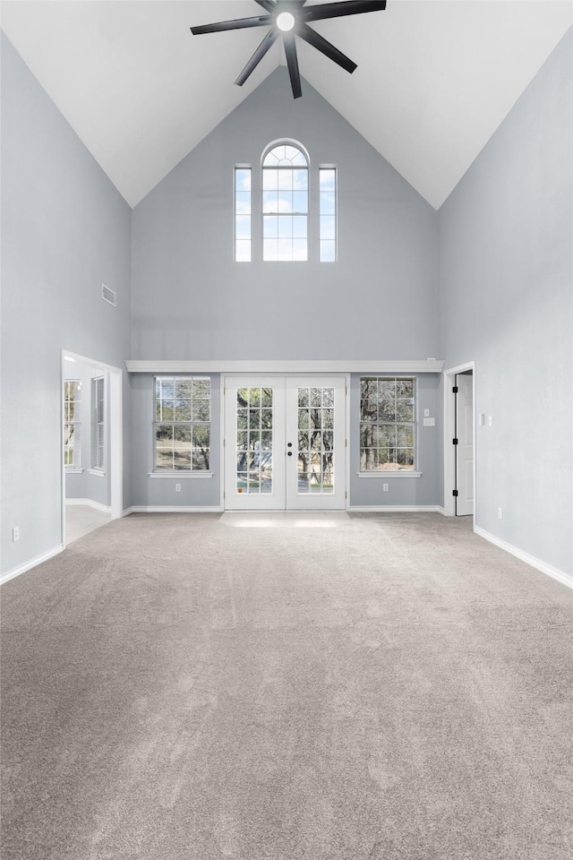 unfurnished living room with high vaulted ceiling, ceiling fan, and carpet flooring