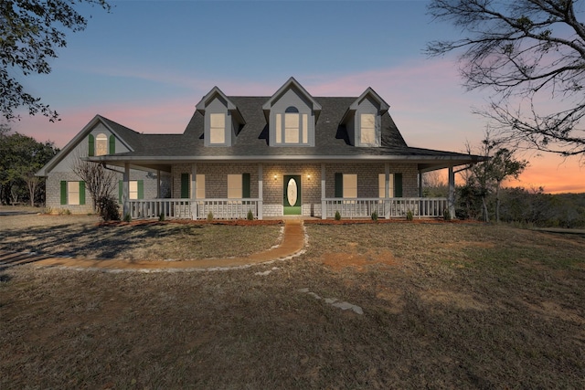 view of front of property with a porch and a yard