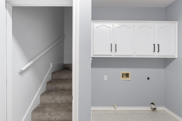 washroom with washer hookup, cabinets, light tile patterned flooring, and electric dryer hookup