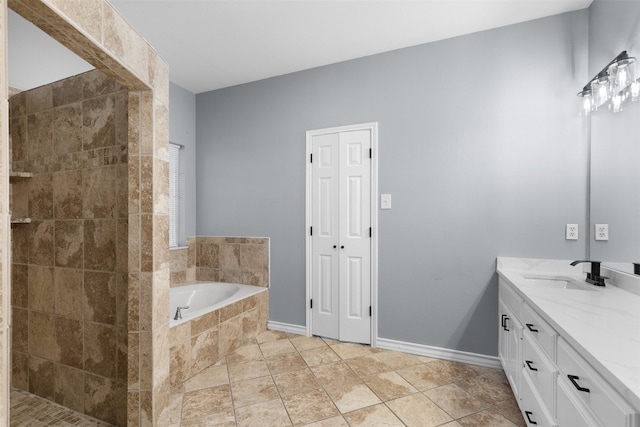 bathroom with vanity, tile patterned floors, and a relaxing tiled tub