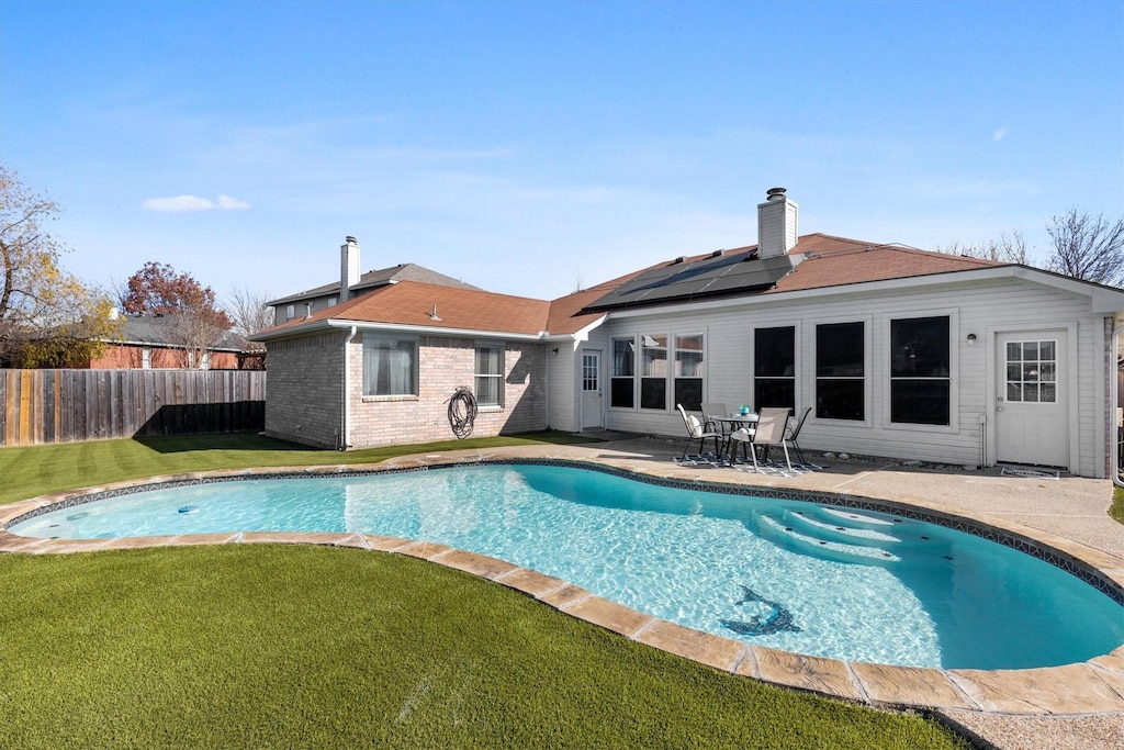 view of swimming pool featuring a lawn and a patio