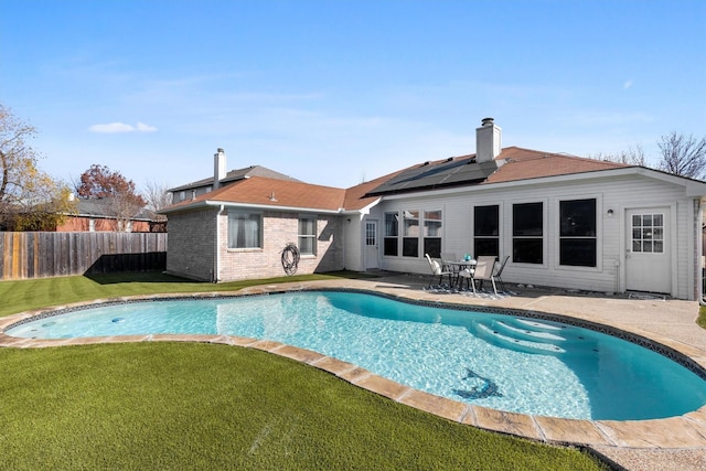 view of swimming pool featuring a lawn and a patio