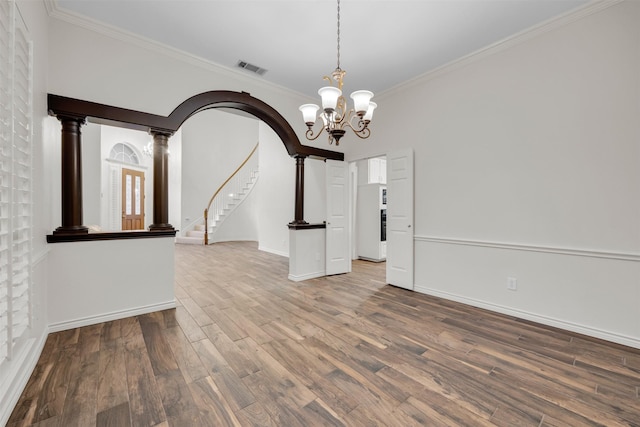 unfurnished dining area featuring ornamental molding, an inviting chandelier, and hardwood / wood-style flooring