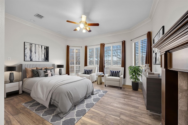 bedroom featuring ornamental molding, ceiling fan, and light hardwood / wood-style flooring