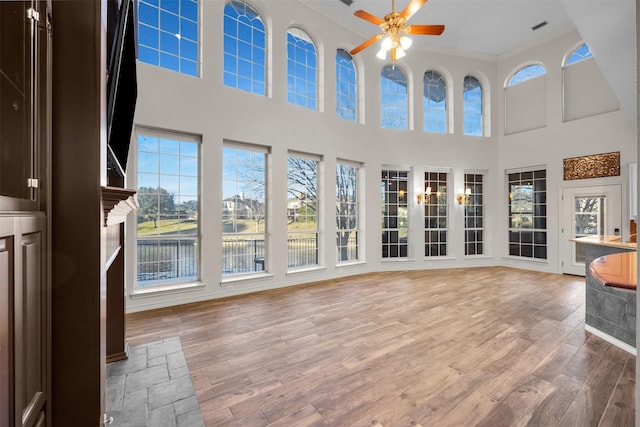 unfurnished sunroom featuring ceiling fan