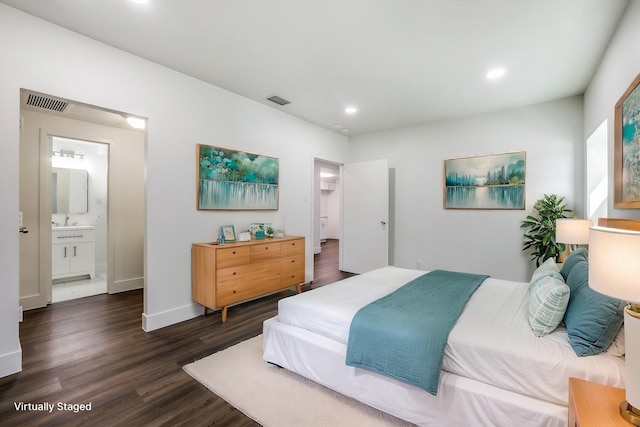 bedroom with sink, dark hardwood / wood-style flooring, and connected bathroom