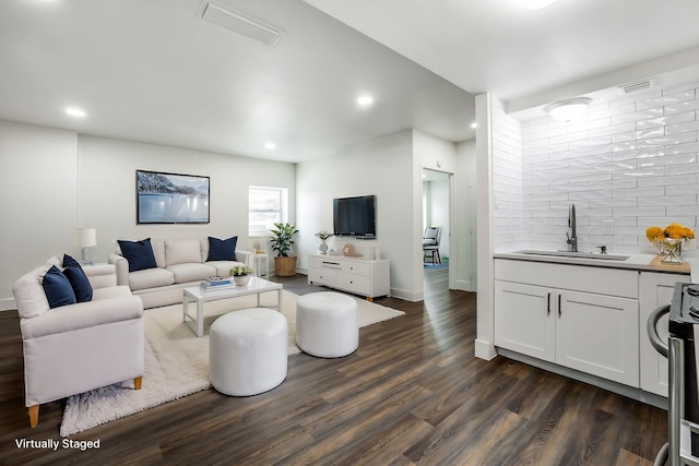 living room featuring wet bar and dark hardwood / wood-style flooring