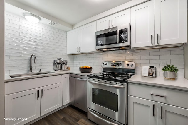 kitchen with sink, white cabinetry, tasteful backsplash, and appliances with stainless steel finishes