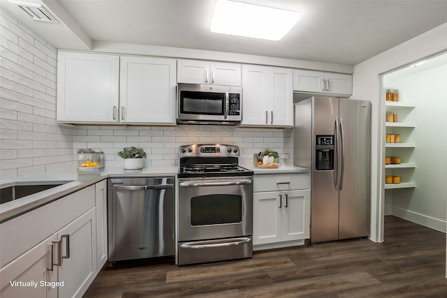 kitchen with appliances with stainless steel finishes, backsplash, and white cabinetry