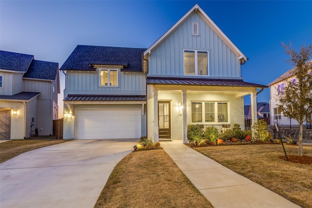 modern inspired farmhouse with a garage, covered porch, and a lawn