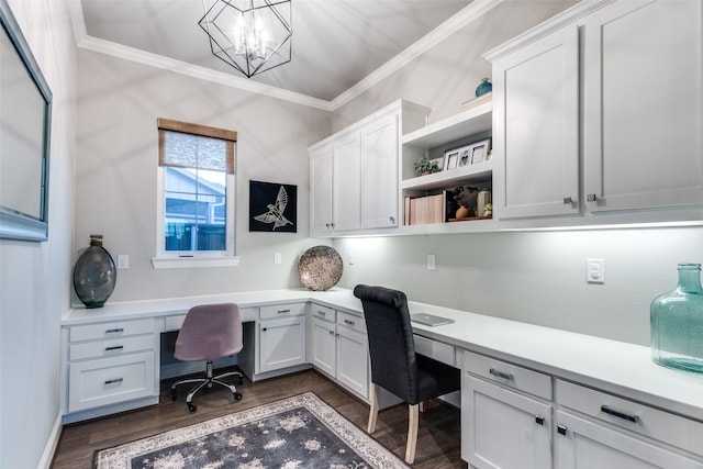 home office featuring an inviting chandelier, built in desk, crown molding, and dark hardwood / wood-style floors