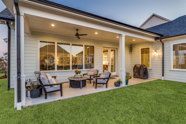 back house at dusk featuring an outdoor fire pit, a patio area, ceiling fan, and a yard