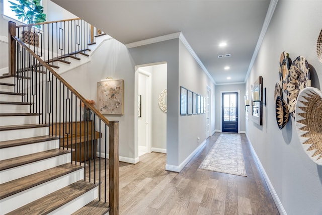 foyer entrance featuring ornamental molding and light hardwood / wood-style floors