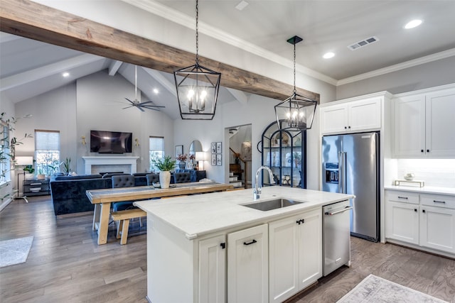 kitchen featuring sink, stainless steel appliances, white cabinetry, and hanging light fixtures