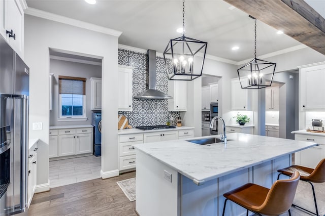 kitchen with an island with sink, dark hardwood / wood-style floors, wall chimney exhaust hood, sink, and white cabinetry