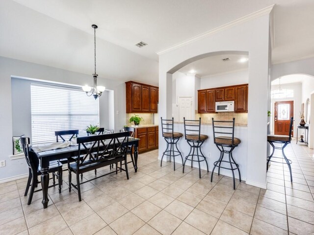 living room featuring crown molding, light tile patterned floors, a fireplace, lofted ceiling, and ceiling fan with notable chandelier