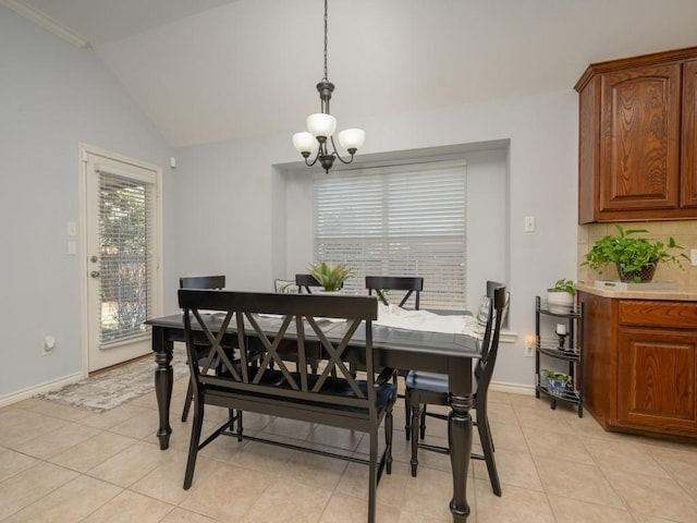 tiled dining area with vaulted ceiling, ornamental molding, and a notable chandelier