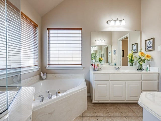 bathroom featuring tiled bath, vanity, tile patterned floors, and vaulted ceiling