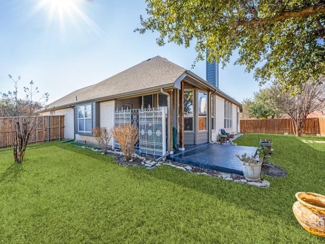 rear view of house featuring a yard and a patio