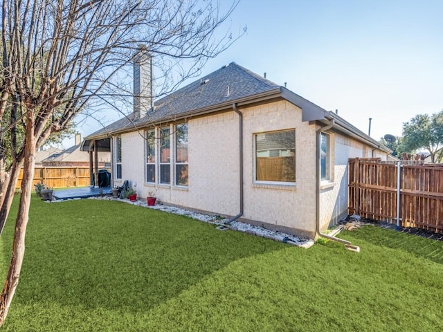 back of house with a patio area and a lawn