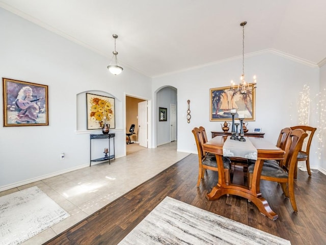 tiled dining room with ornamental molding and an inviting chandelier