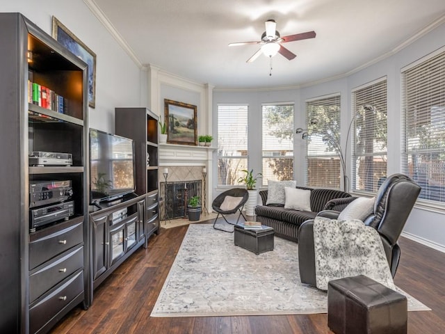 living room featuring a fireplace, ceiling fan, ornamental molding, and dark hardwood / wood-style floors