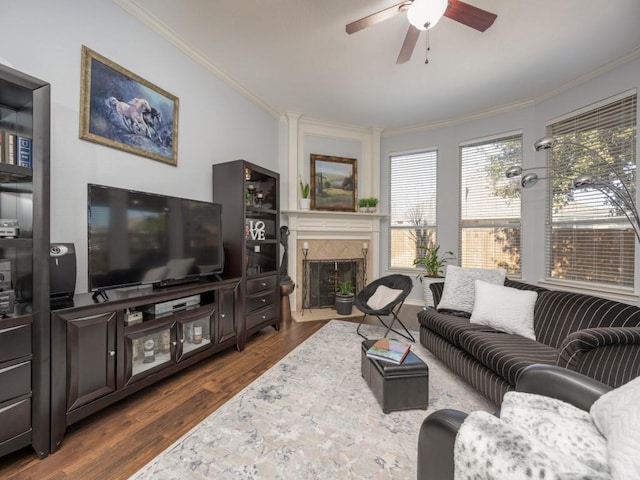 living room with a premium fireplace, ceiling fan, ornamental molding, and dark hardwood / wood-style flooring