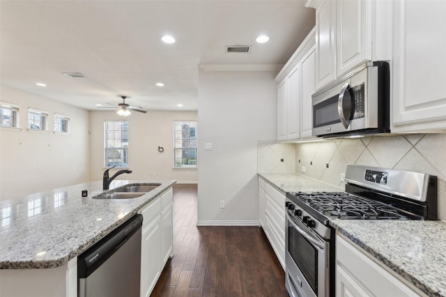 kitchen with white cabinets, stainless steel appliances, light stone countertops, ceiling fan, and sink