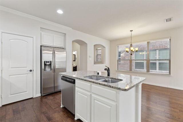 kitchen featuring sink, stainless steel appliances, white cabinetry, a chandelier, and a kitchen island with sink