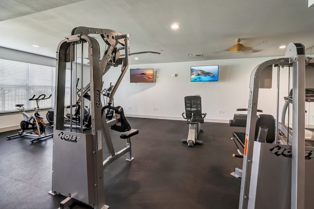 gym featuring a textured ceiling and ceiling fan