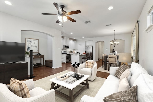 living room featuring sink, ceiling fan with notable chandelier, and light hardwood / wood-style flooring