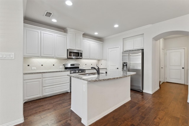 kitchen with sink, white cabinets, light stone countertops, a center island with sink, and appliances with stainless steel finishes