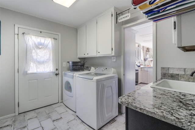 clothes washing area featuring sink, cabinets, and washing machine and dryer