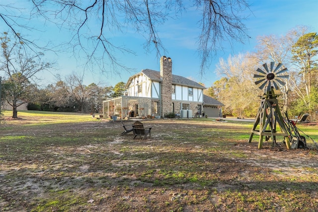 back of house featuring a fire pit, central AC unit, and a garage