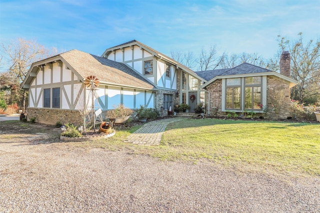 english style home featuring a front yard