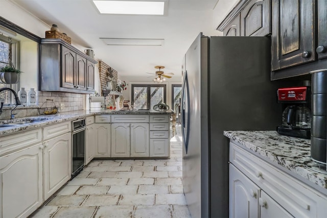 kitchen with sink, ceiling fan, a healthy amount of sunlight, and tasteful backsplash