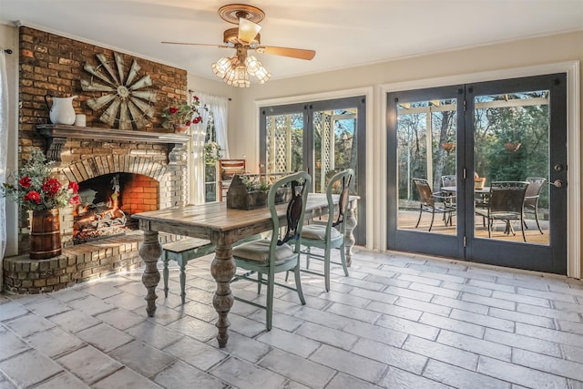 unfurnished dining area with ceiling fan, french doors, and a brick fireplace