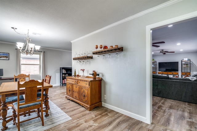 dining space with ceiling fan with notable chandelier, ornamental molding, and hardwood / wood-style floors