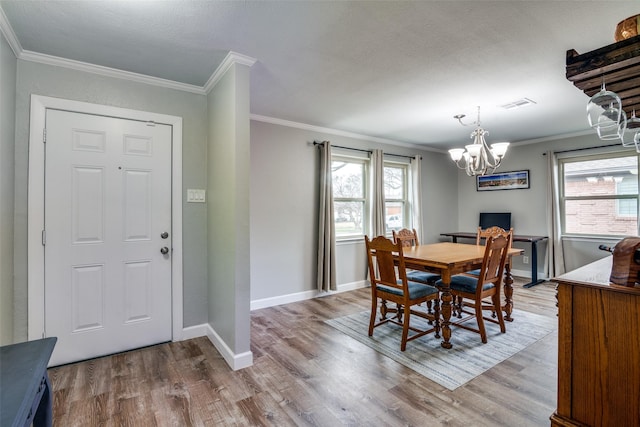 dining space featuring ornamental molding and light hardwood / wood-style floors