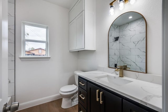 bathroom featuring toilet, vanity, walk in shower, and hardwood / wood-style flooring