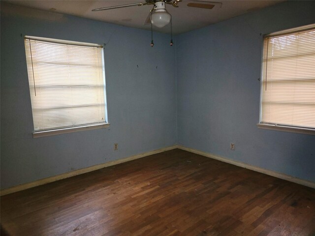 empty room featuring dark wood-type flooring and ceiling fan