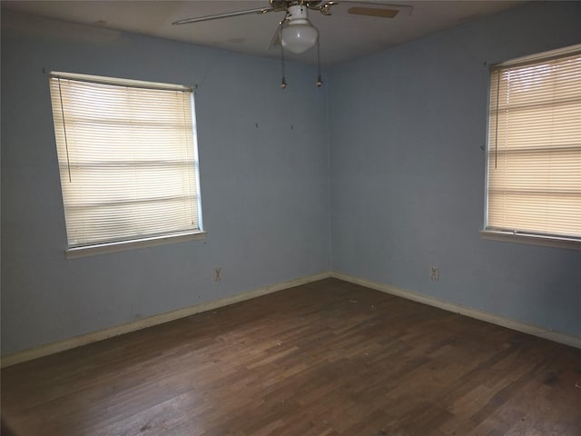 unfurnished room with dark wood-type flooring, a wealth of natural light, and ceiling fan