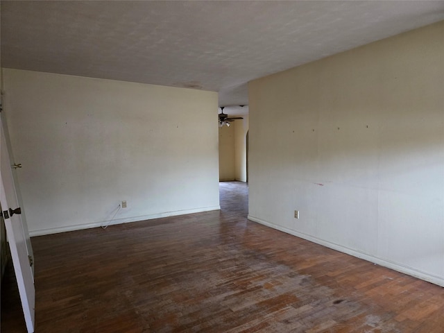 empty room featuring a textured ceiling, dark wood-type flooring, and ceiling fan