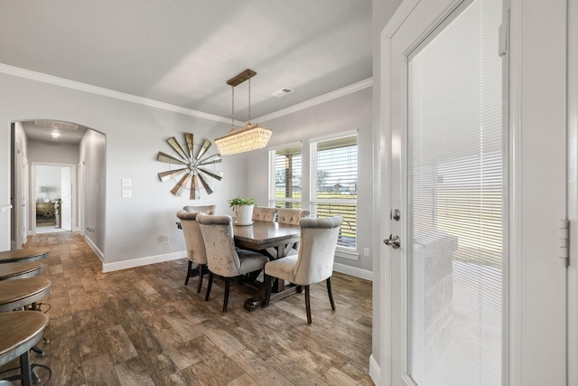 dining room with dark wood-type flooring and crown molding