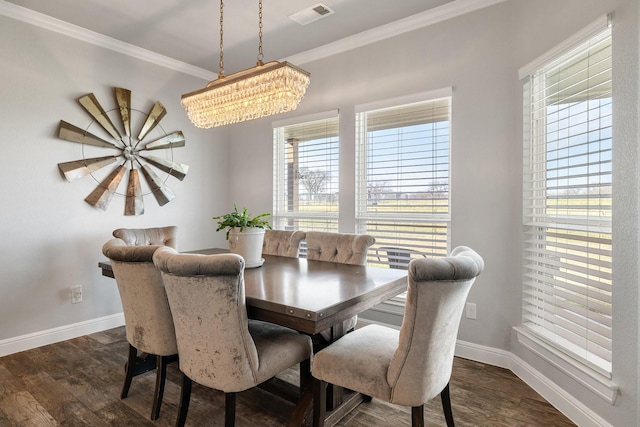 dining space with dark wood-type flooring, an inviting chandelier, and crown molding