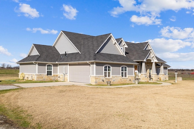 craftsman inspired home featuring a porch, a front yard, and a garage