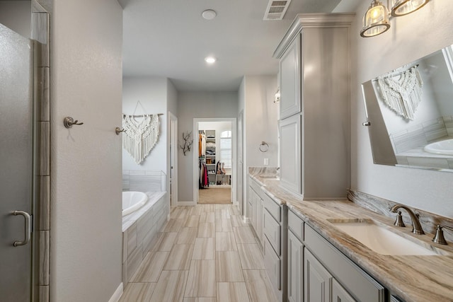 bathroom featuring vanity and shower with separate bathtub