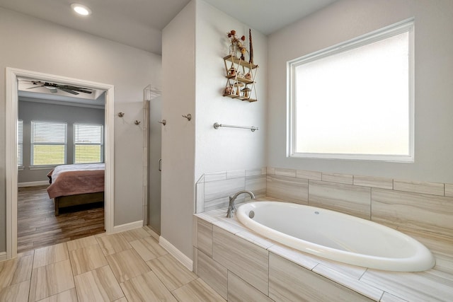 bathroom featuring shower with separate bathtub and ceiling fan